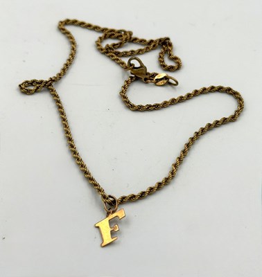 Lot 531 - A 9ct gold rope necklace with letter F pendant,...