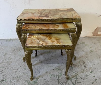 Lot 857 - A nest of three onyx marble topped side tables...