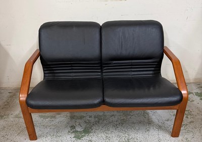 Lot 18 - A black faux leather two seater sofa by Leyform
