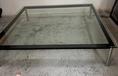 Lot 68 - A large glass coffee table sitting on a black...