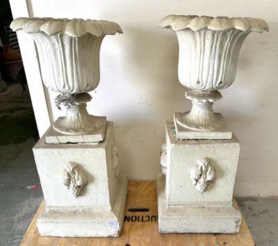 Lot 243 - A pair of stone garden urns on square pedestal...