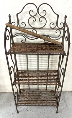 Lot 841 - A wrought iron shelf with three shelves and...