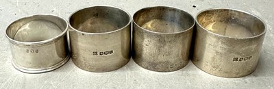 Lot 489 - Four sterling silver napkin rings with various...