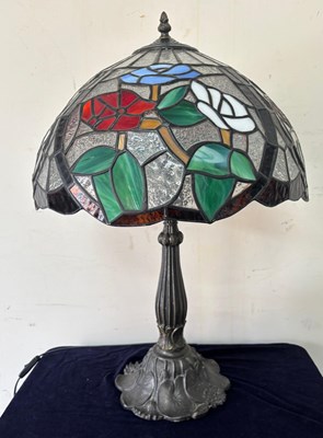 Lot 259 - A Tiffany-style table lamp features a stained...