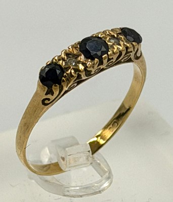 Lot 552 - A 9ct gold three stone sapphire ring,...