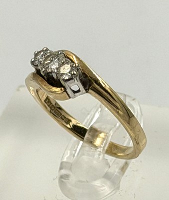 Lot 556 - A 9ct gold three stone diamond ring,...