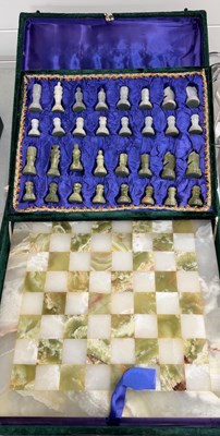 Lot 651 - A cased stone chess set with green and white...