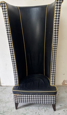 Lot 181 - This dramatic black leather armchair features...