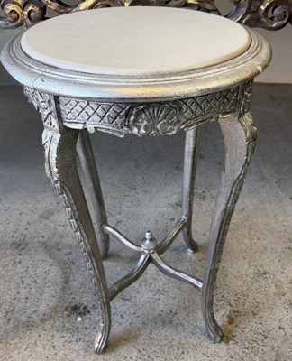 Lot 106 - A round side table with metal finish carved...
