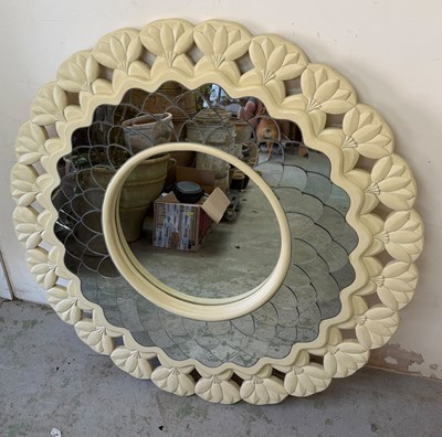 Lot 253 - A wall mirror features a floral scalloped...